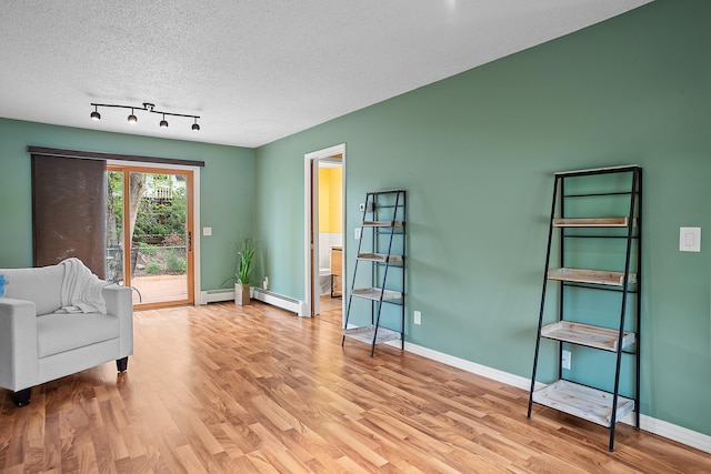 3520 Arizona St, Rapid City, SD 57701 - sitting room with wood finished floors, a textured ceiling, baseboards, and a baseboard radiator