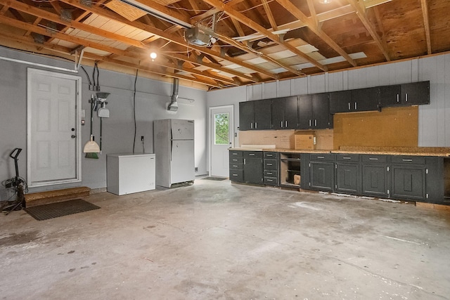 3520 Arizona St, Rapid City, SD 57701 - garage with freestanding refrigerator, refrigerator, and a workshop area