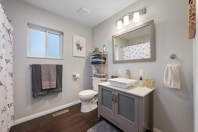 733 Zenith St, Belle Fourche, SD 57717 - full bath featuring wood finished floors, toilet, vanity, baseboards, and a shower with shower curtain