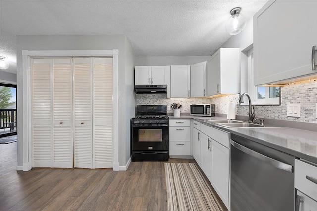 733 Zenith St, Belle Fourche, SD 57717 - kitchen featuring appliances with stainless steel finishes, a sink, dark wood-style floors, backsplash, and a textured ceiling