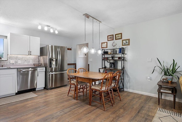 733 Zenith St, Belle Fourche, SD 57717 - dining space featuring wood finished floors, track lighting, baseboards, and a textured ceiling