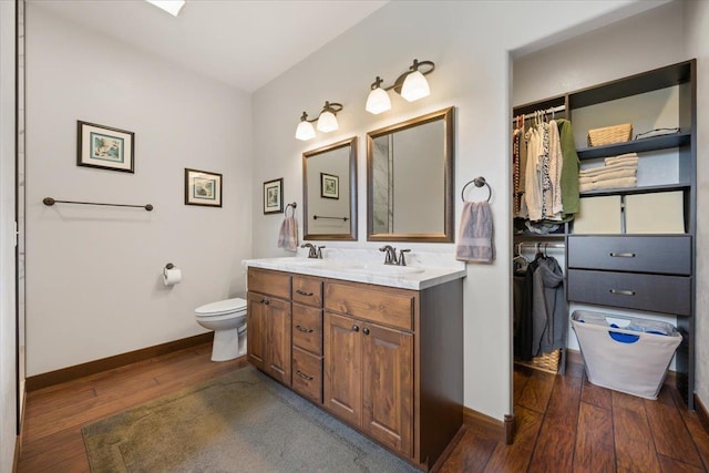 11132 Bogey Cir, Lead, SD 57754 - bathroom with wood-type flooring, baseboards, double vanity, and toilet