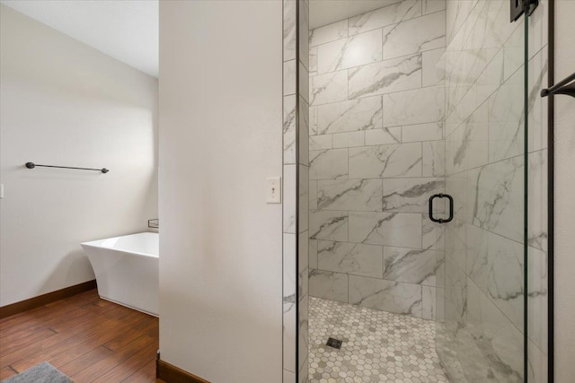 11132 Bogey Cir, Lead, SD 57754 - bathroom with a shower stall, hardwood / wood-style floors, a freestanding tub, and baseboards