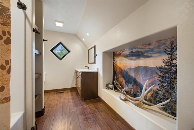 11132 Bogey Cir, Lead, SD 57754 - bathroom with hardwood / wood-style floors, vanity, lofted ceiling, and baseboards