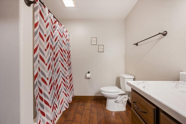 11132 Bogey Cir, Lead, SD 57754 - bathroom featuring hardwood / wood-style flooring, toilet, vanity, a shower with curtain, and baseboards