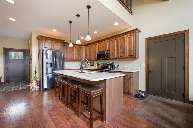 11132 Bogey Cir, Lead, SD 57754 - kitchen with stainless steel appliances, a sink, dark wood-type flooring, a breakfast bar, and recessed lighting
