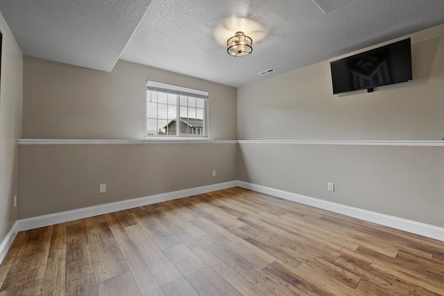 7350 Brighton St, Summerset, SD 57718 - empty room featuring a textured ceiling, hardwood / wood-style floors, and baseboards