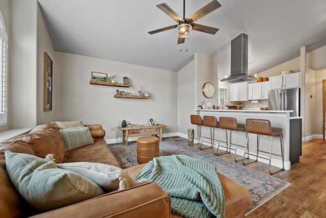 7350 Brighton St, Summerset, SD 57718 - living area with vaulted ceiling, ceiling fan, light wood finished floors, and baseboards