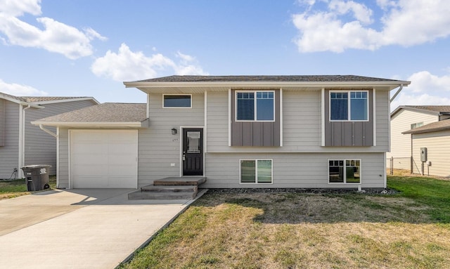 655 Bomber Way, Box Elder, SD 57719 - view of front facade with concrete driveway, a garage, board and batten siding, and a front yard