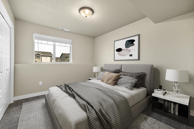 655 Bomber Way, Box Elder, SD 57719 - bedroom with a closet, baseboards, a textured ceiling, and carpet floors
