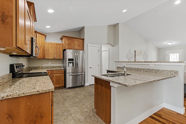 6212 Poppy Ct, Rapid City, SD 57702 - kitchen with stainless steel appliances, lofted ceiling, an island with sink, light stone counters, and a sink