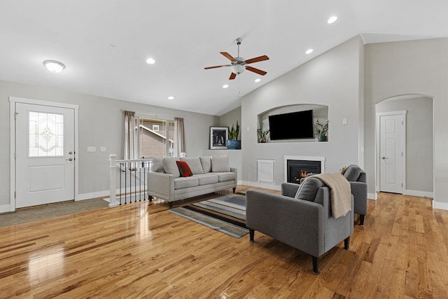 6212 Poppy Ct, Rapid City, SD 57702 - living area featuring arched walkways, a ceiling fan, vaulted ceiling, wood finished floors, and baseboards