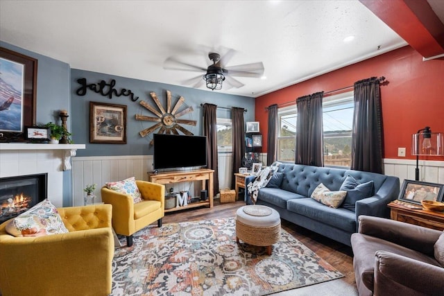 30 Adams St, Deadwood, SD 57732 - living area featuring wainscoting, a fireplace, a ceiling fan, and wood finished floors