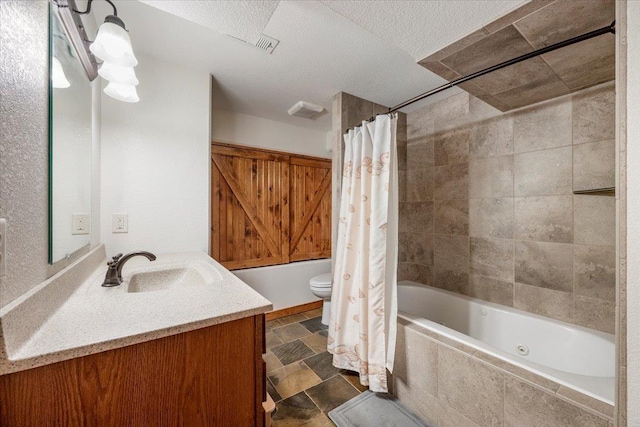 2315 Palisades Loop, Sturgis, SD 57785 - bathroom featuring tiled shower / bath combo, vanity, toilet, a textured ceiling, and stone finish floors