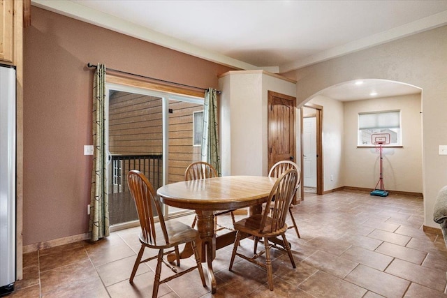 2315 Palisades Loop, Sturgis, SD 57785 - dining space featuring arched walkways, baseboards, plenty of natural light, and light tile patterned flooring