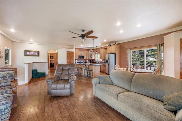 2315 Palisades Loop, Sturgis, SD 57785 - living room with dark wood-style floors, ceiling fan, arched walkways, recessed lighting, and crown molding