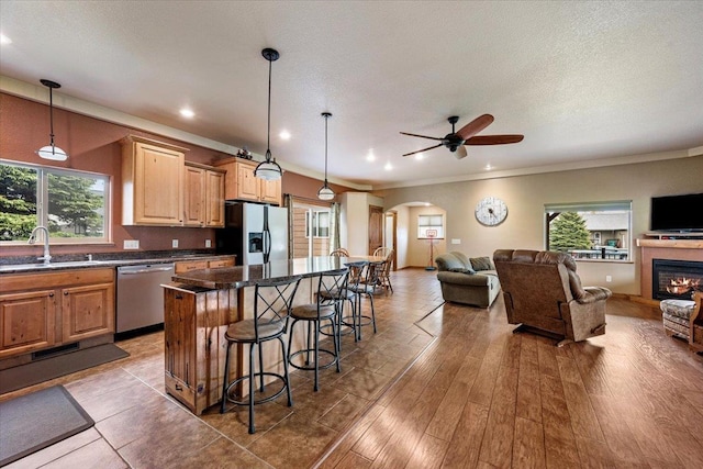 2315 Palisades Loop, Sturgis, SD 57785 - kitchen featuring appliances with stainless steel finishes, open floor plan, arched walkways, a breakfast bar, and ceiling fan