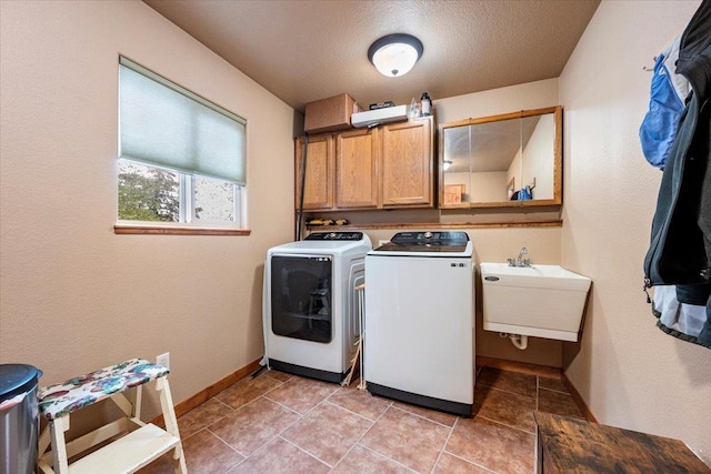 2315 Palisades Loop, Sturgis, SD 57785 - laundry room featuring washing machine and clothes dryer, cabinet space, baseboards, and light tile patterned floors