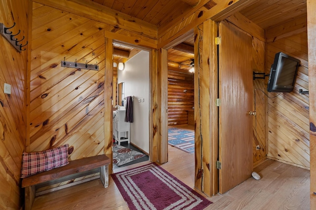 28013 Cascade Rd, Hot Springs, SD 57747 - hallway featuring light wood-type flooring, wood ceiling with exposed beams, log walls, and wooden walls