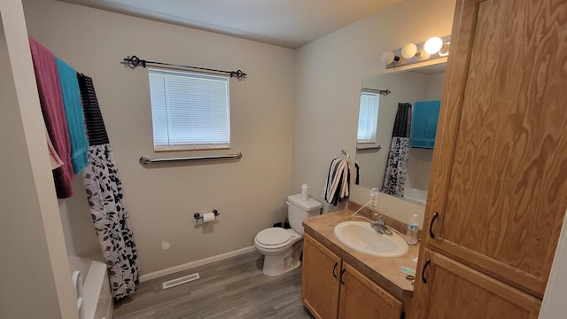 102 10th Ave, Belle Fourche, SD 57717 - full bath with wood finished floors, vanity, toilet, baseboards, and shower / tub combo