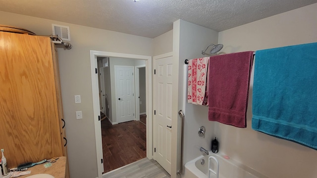 102 10th Ave, Belle Fourche, SD 57717 - bathroom featuring wood finished floors and a textured ceiling