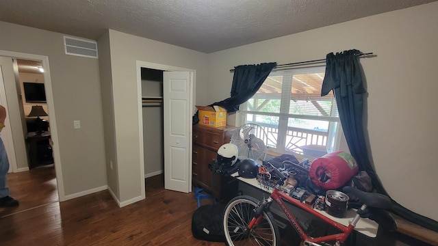 102 10th Ave, Belle Fourche, SD 57717 - bedroom featuring wood finished floors, a textured ceiling, a closet, and baseboards