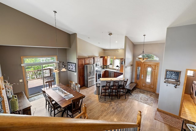 342 Enchantment Rd, Rapid City, SD 57701 - dining area featuring high vaulted ceiling, light wood finished floors, baseboards, and washer / clothes dryer