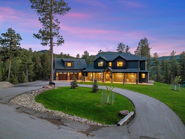 3135 American Eagle Rd, Spearfish, SD 57783 - view of front of property featuring curved driveway, covered porch, a lawn, and a garage