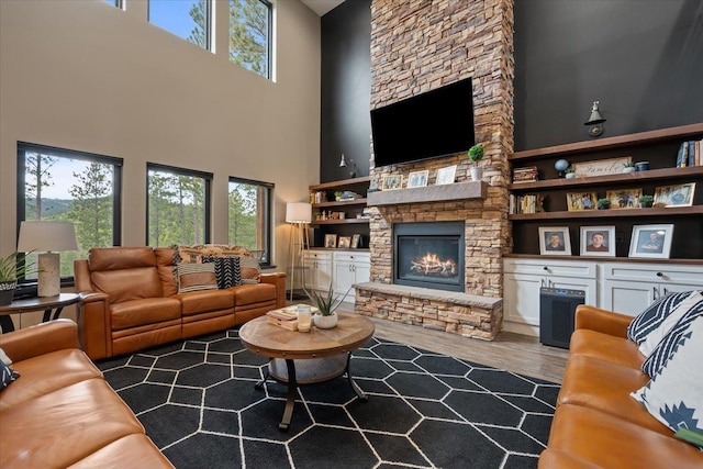 3135 American Eagle Rd, Spearfish, SD 57783 - living room featuring a fireplace, wood finished floors, and a towering ceiling