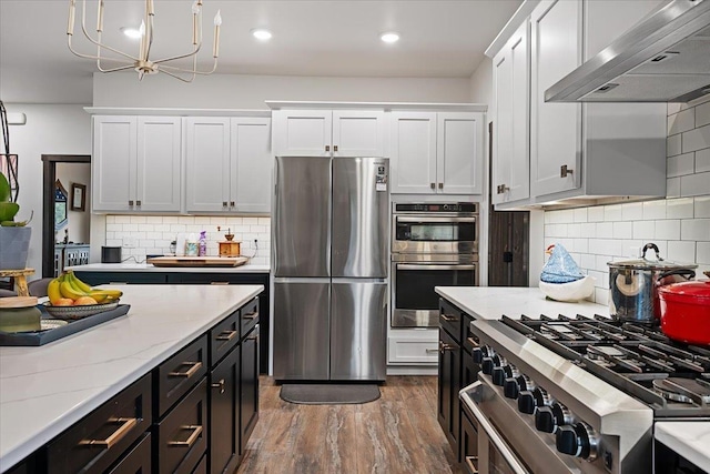 3135 American Eagle Rd, Spearfish, SD 57783 - kitchen featuring stainless steel appliances, wall chimney range hood, white cabinetry, backsplash, and recessed lighting
