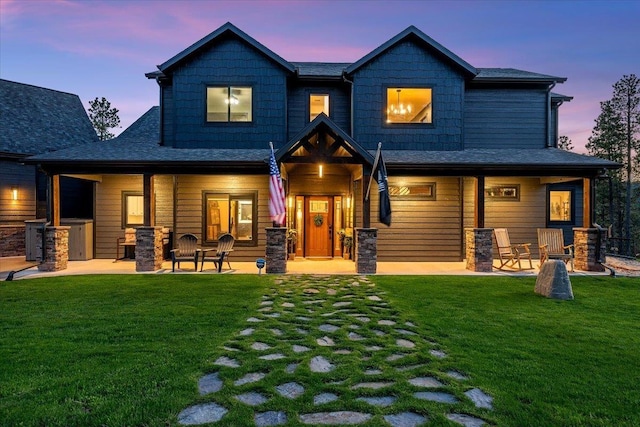 3135 American Eagle Rd, Spearfish, SD 57783 - back of house at dusk with a lawn, roof with shingles, and a patio