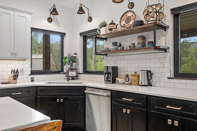 3135 American Eagle Rd, Spearfish, SD 57783 - kitchen with stainless steel dishwasher, dark cabinetry, a sink, and decorative backsplash