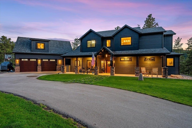 3135 American Eagle Rd, Spearfish, SD 57783 - view of front of property featuring covered porch, driveway, a lawn, and stone siding
