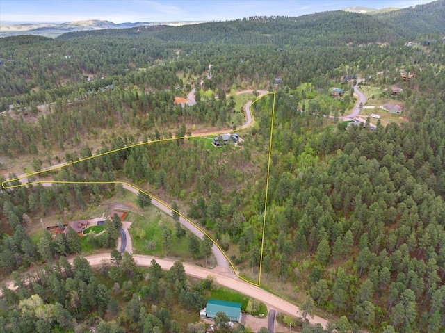 3135 American Eagle Rd, Spearfish, SD 57783 - aerial view of property and surrounding area featuring a heavily wooded area, property parcel outlined, and a mountainous background