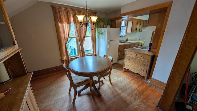 57 Lincoln Ave, Deadwood, SD 57732 - dining space with a chandelier, hardwood / wood-style floors, baseboards, and vaulted ceiling