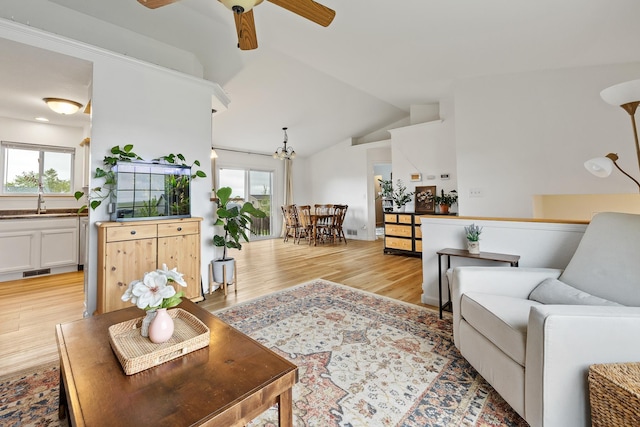 491 Freude Ln, Box Elder, SD 57719 - living area with light wood-type flooring, lofted ceiling, a ceiling fan, and a chandelier