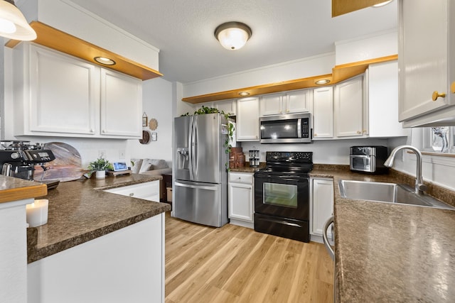491 Freude Ln, Box Elder, SD 57719 - kitchen with stainless steel appliances, a sink, light wood-style flooring, and white cabinetry
