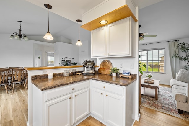 491 Freude Ln, Box Elder, SD 57719 - kitchen featuring a peninsula, light wood finished floors, white cabinetry, a chandelier, and vaulted ceiling