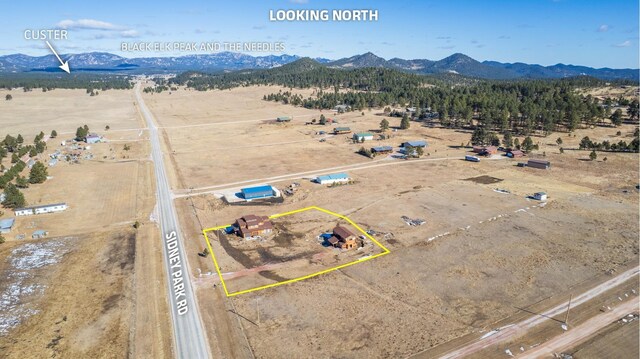 25426 Sidney Park Rd, Custer, SD 57730 - aerial view of sparsely populated area with mountains, property parcel outlined, and a desert landscape