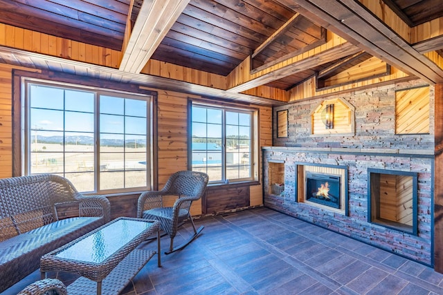 25426 Sidney Park Rd, Custer, SD 57730 - sitting room featuring wooden ceiling with exposed beams, wooden walls, and a stone fireplace