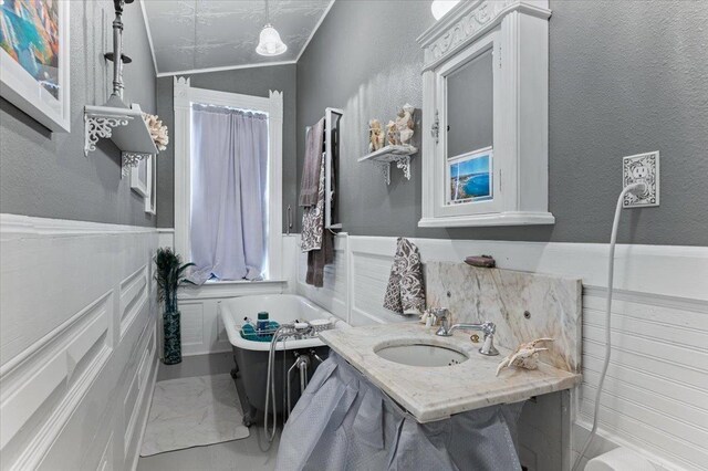 118 S Galena St, Lead, SD 57754 - full bath with a sink, a soaking tub, and wainscoting