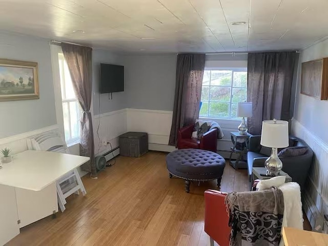 121 S Stone St, Lead, SD 57754 - living room featuring light wood-style flooring, a baseboard heating unit, a baseboard radiator, and wainscoting
