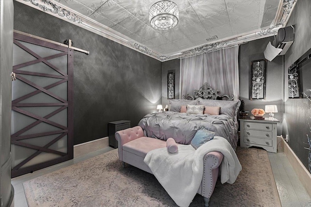 1231/2 Stone St, Lead, SD 57754 - bedroom with an ornate ceiling, a barn door, wood finished floors, a chandelier, and baseboards
