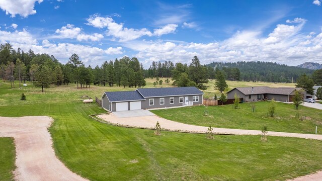 151 Surrey Ln, Custer, SD 57730 - view of front of house featuring concrete driveway, a front lawn, an attached garage, and a wooded view