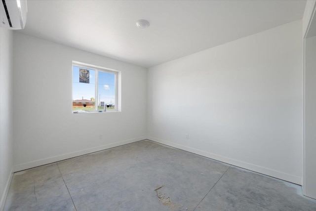 10884 Eagle Ct, Belle Fourche, SD 57717 - spare room with concrete flooring, an AC wall unit, and baseboards