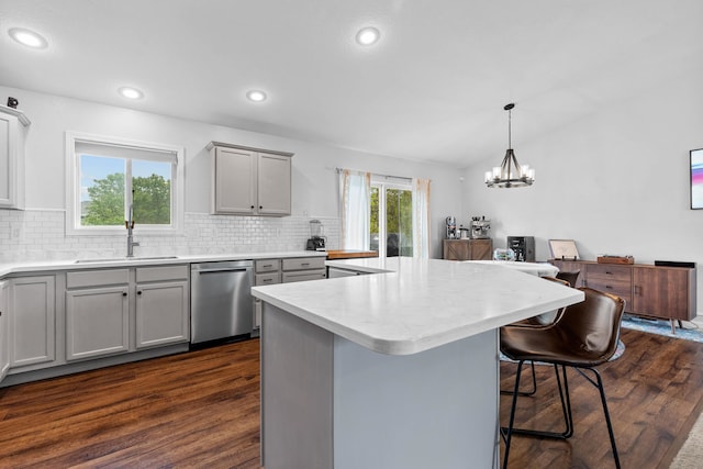 4312 Mile High Ave, Rapid City, SD 57701 - kitchen featuring stainless steel dishwasher, a sink, gray cabinetry, dark wood-type flooring, and decorative backsplash