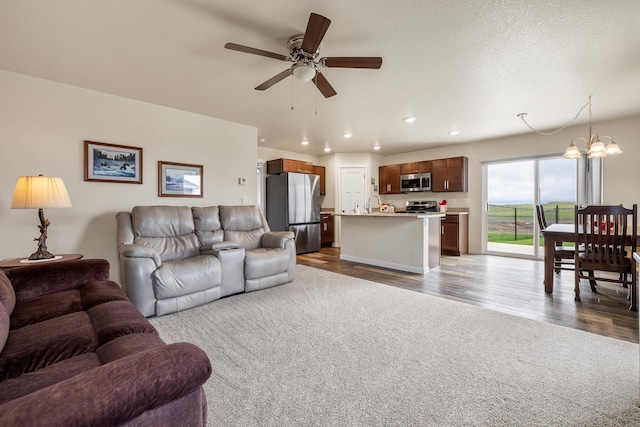 516 Aaron Ct, Rapid City, SD 57703 - living area with a ceiling fan, a chandelier, dark colored carpet, recessed lighting, and dark wood-type flooring