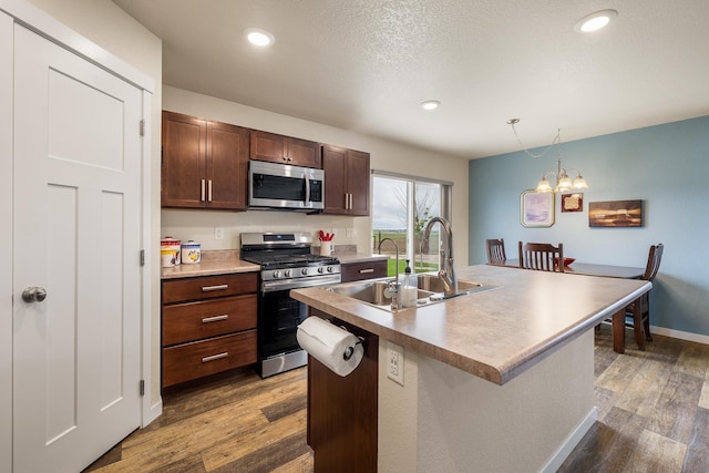 516 Aaron Ct, Rapid City, SD 57703 - kitchen featuring stainless steel appliances, a sink, wood finished floors, pendant lighting, and recessed lighting