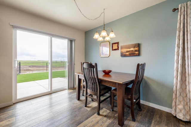 516 Aaron Ct, Rapid City, SD 57703 - dining area with a chandelier, wood finished floors, and baseboards