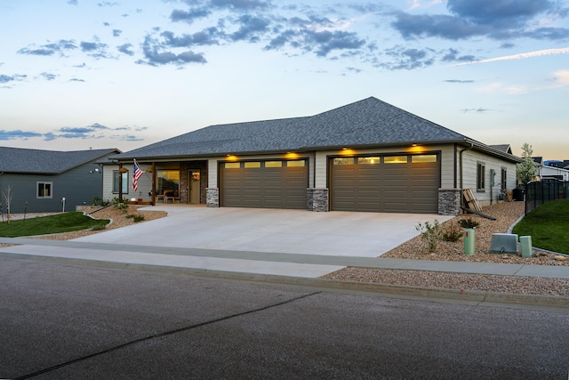 2259 Suntory Ave, Spearfish, SD 57783 - view of front facade featuring an attached garage, driveway, roof with shingles, and stone siding